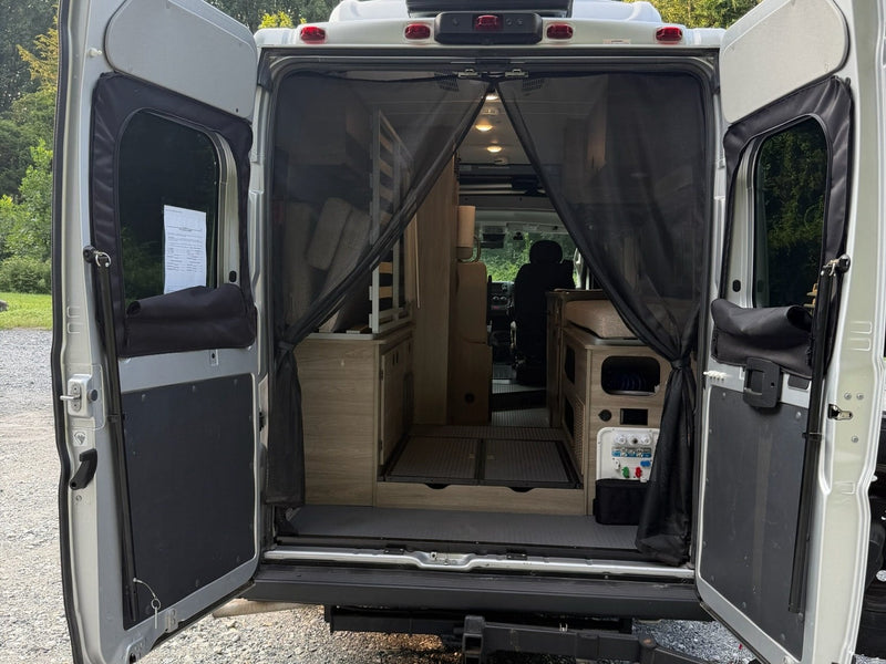  and a window offering a lush green view.|Silver Winnebago Ram ProMaster camper van RV rental — photo 20