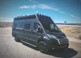Dark grey NOOVO RV rental camper van parked on a sunny desert road. Perfect for your next adventure or road trip.