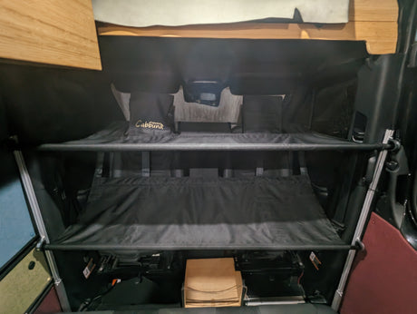 Dual Cabbunk beds inside an RV rental, providing a compact sleeping solution for camper van adventures.