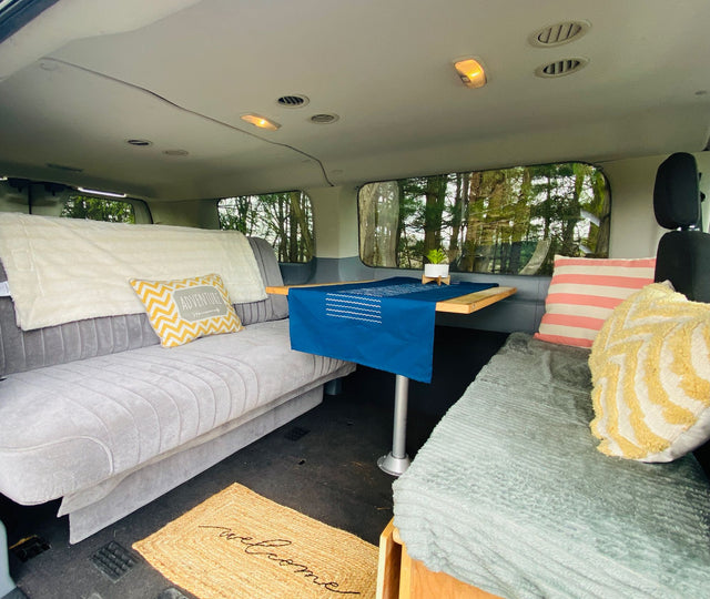  parked on grass. Ideal for mobile adventures.|Two vibrant RV rental camper vans with rooftop tents open
