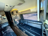 Luxury RV rental interior with spacious black leather seating, a counter area, and warm ambient lighting.