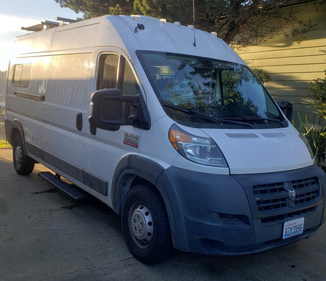 White Ram ProMaster van, ideal for rv rental adventures. Features roof rack, side windows, and step.
