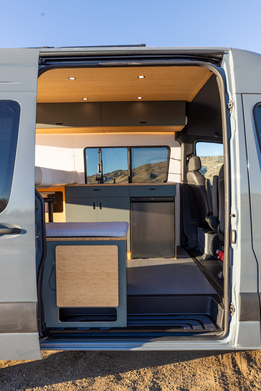  is parked on a scenic mountain road. Perfect for travel adventures!|Stunning RV rental interior with kitchen