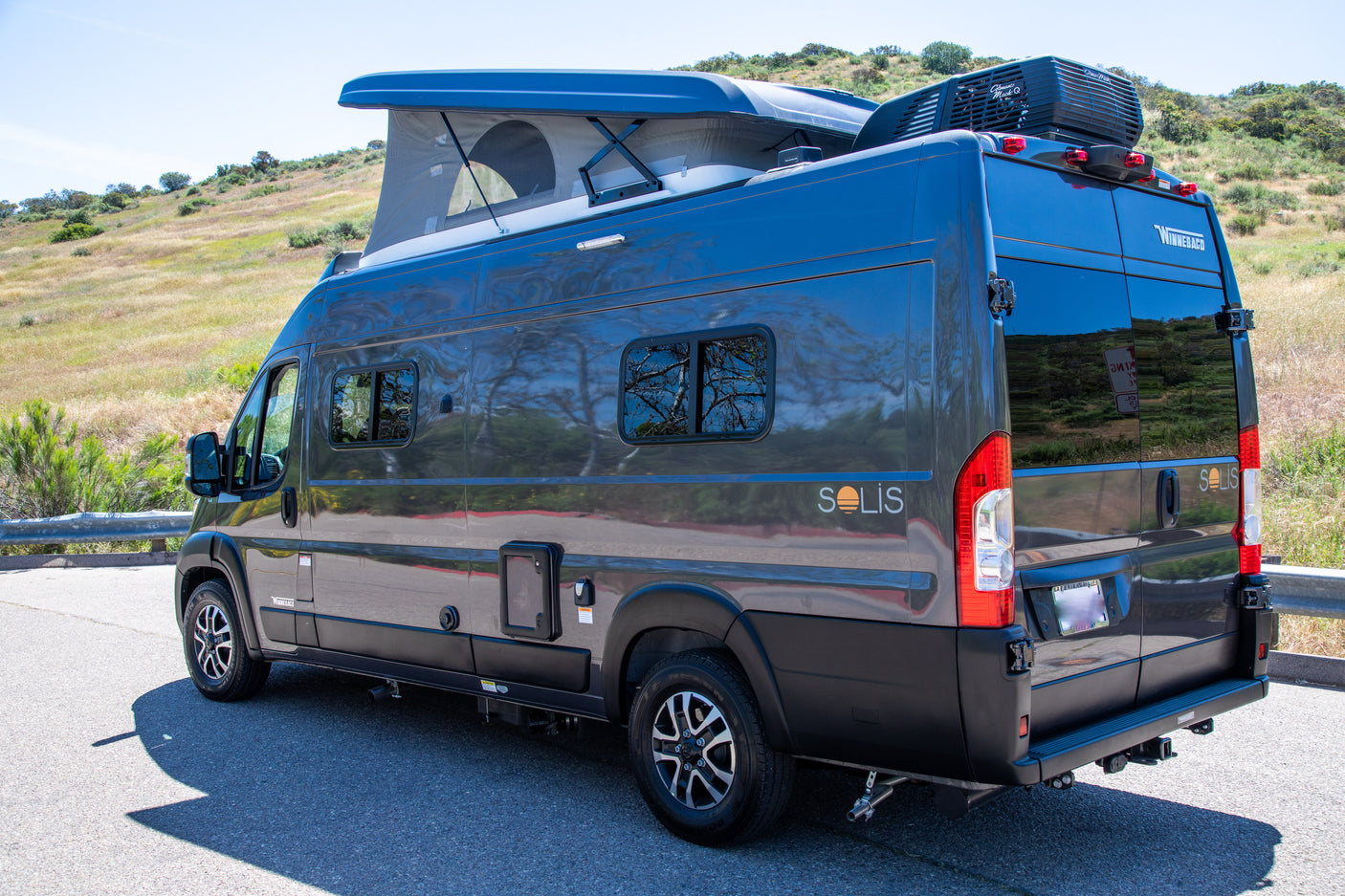 Dark gray Winnebago Solis camper van with pop-top roof, perfect for your next RV rental adventure.