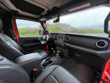 Inside a modern RV rental vehicle, featuring black leather interior, dashboard, and the view of a scenic road ahead.