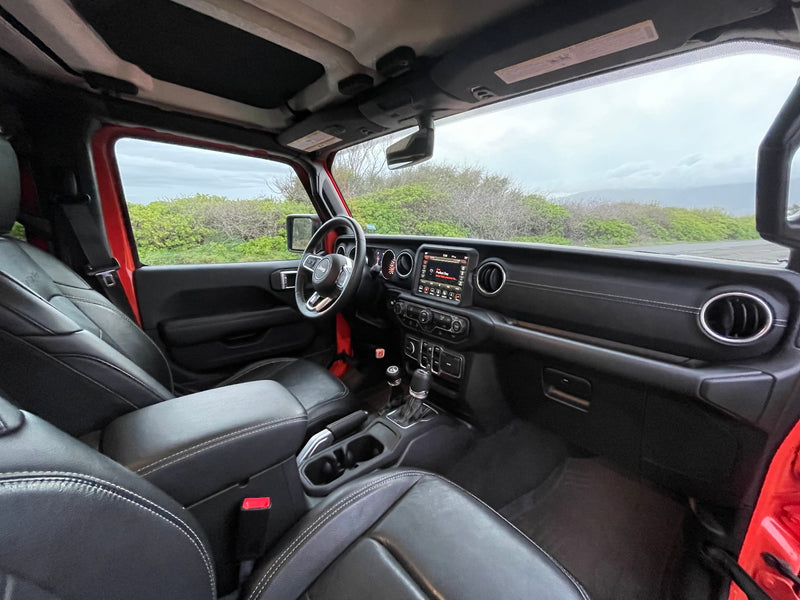 Inside a modern RV rental vehicle, featuring black leather interior, dashboard, and the view of a scenic road ahead. — photo 10
