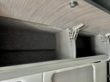 Overhead storage in this RV rental: spacious compartments with light wood-grain texture, dark interiors, and strong spring hinges.