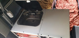 Compact RV rental kitchen features a Dometic sink and Anker power strip, ideal for on-the-go living.