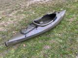 A green Sundolphin kayak rests on grass, perfect for watersports when you travel with an RV rental.