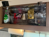 RV rental kitchen cabinet, neatly organized with coffee supplies, dish soap, and insulated lining for travel.