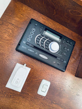 RV rental interior with a Jensen stereo, AC fan switch, and electrical safety device on a wooden surface.