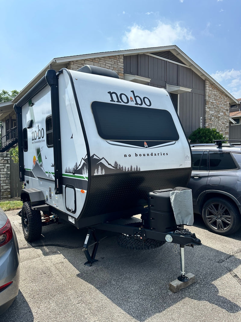 This white and black No Boundaries travel trailer, featuring mountain graphics, is ready for your next RV rental adventure. — photo 16