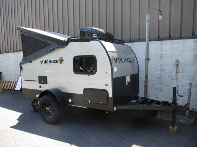 Explore this compact Viking pop-up travel trailer, ideal for an **RV rental** adventure with its rugged design and off-road tires.
