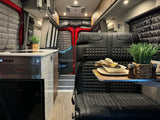 Explore this RV rental's modern kitchen with cooktop & fridge, comfy black leather dining seats, and quilted window covers.