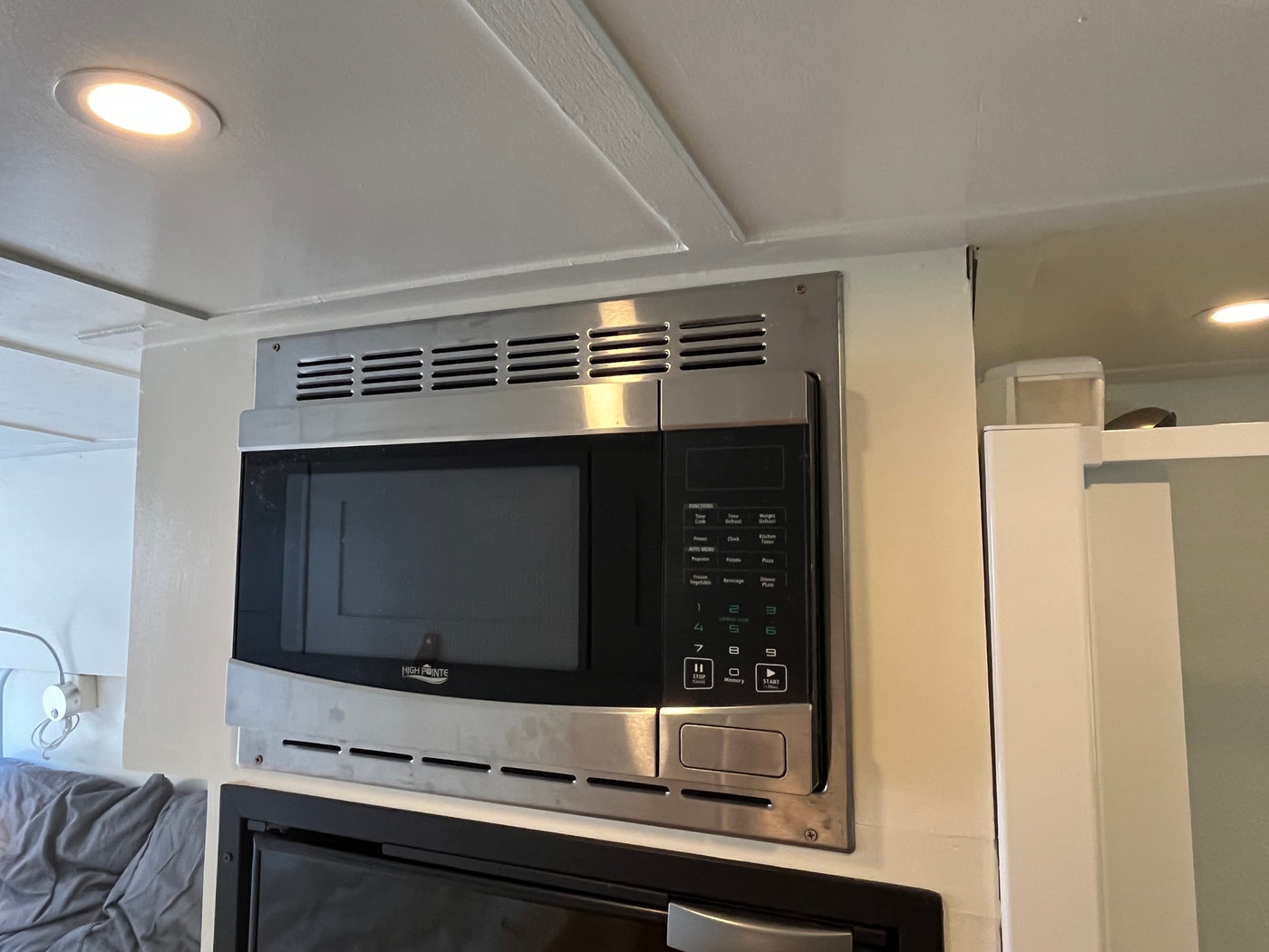 A High Pointe stainless steel microwave oven, mounted in an rv rental. It features a digital control panel and is situated under ceiling lighting. — photo 14