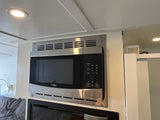 A High Pointe stainless steel microwave oven, mounted in an rv rental. It features a digital control panel and is situated under ceiling lighting.