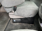 RV rental interior: Gray fabric seat with a mounted power strip, offering convenient power outlets under the seat.