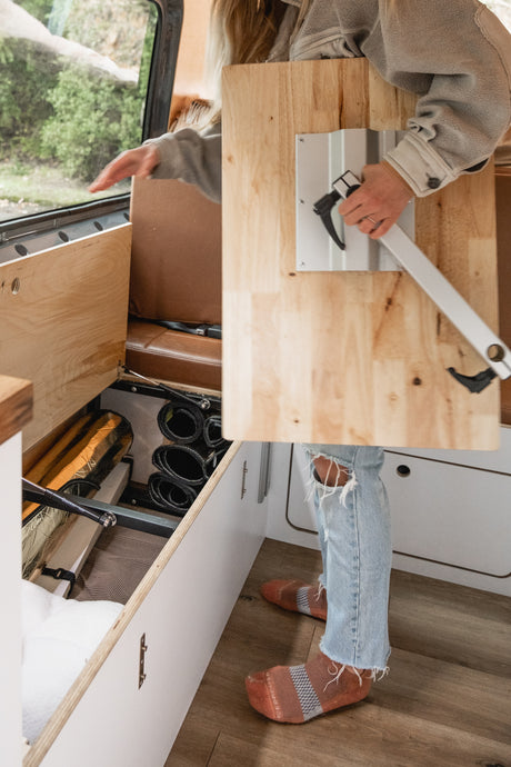 Setting up a portable table in an RV rental. Organized under-seat storage visible for travel.