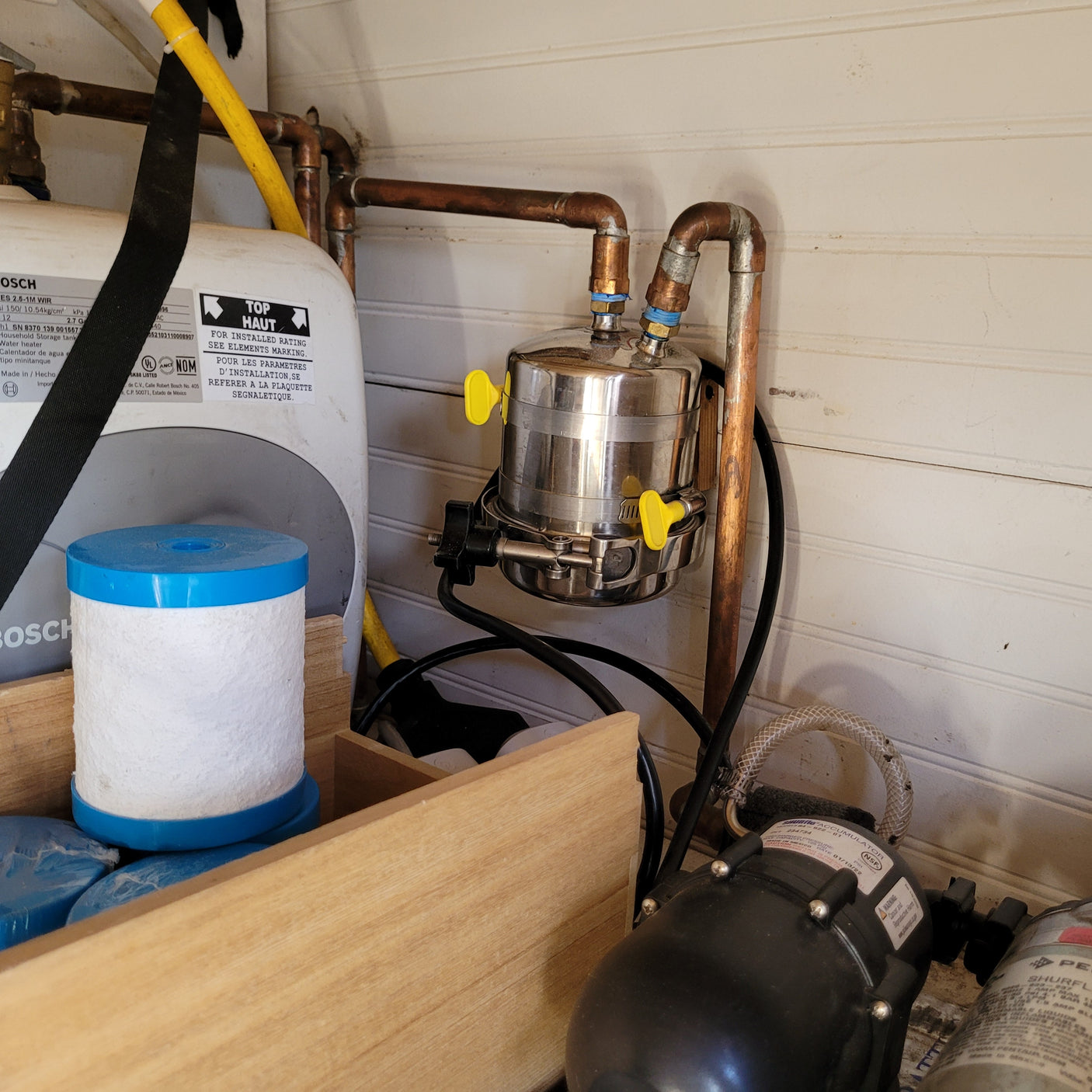 RV rental's water system, featuring a Bosch compact water heater, Shurflo pump, and filter for fresh water.