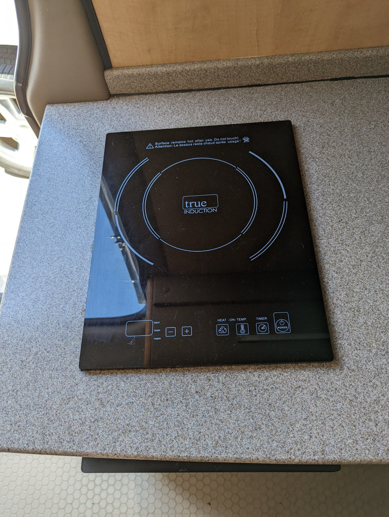 Black True Induction cooktop on a speckled grey countertop, a convenient cooking appliance for your RV rental kitchen. — photo 20