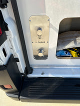 RV rental camper van's x noovo outdoor water utility panel with faucet and mixer, beside open storage.