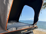 Rooftop tent camping with an RV rental provides stunning ocean views from this Roofnest setup on a beach.