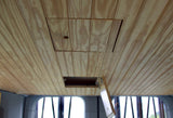 RV rental wooden ceiling with an open access hatch, revealing an internal compartment.