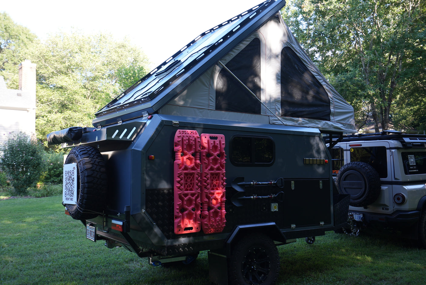 This off-road pop-top trailer, equipped for overlanding, features a "RENT ME!" sign. Perfect for your next RV rental adventure!