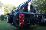 This off-road pop-top trailer, equipped for overlanding, features a "RENT ME!" sign. Perfect for your next RV rental adventure!