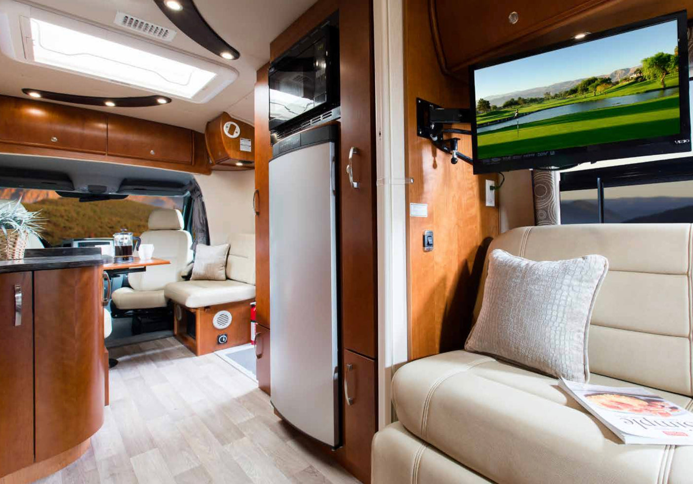 Spacious rv rental interior with living area, TV, and full kitchen. Enjoy comfort & convenience on your next adventure.