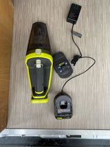 Ryobi ONE+ handheld vacuum, battery, and charger on wood-like flooring, ideal for maintaining an RV rental.