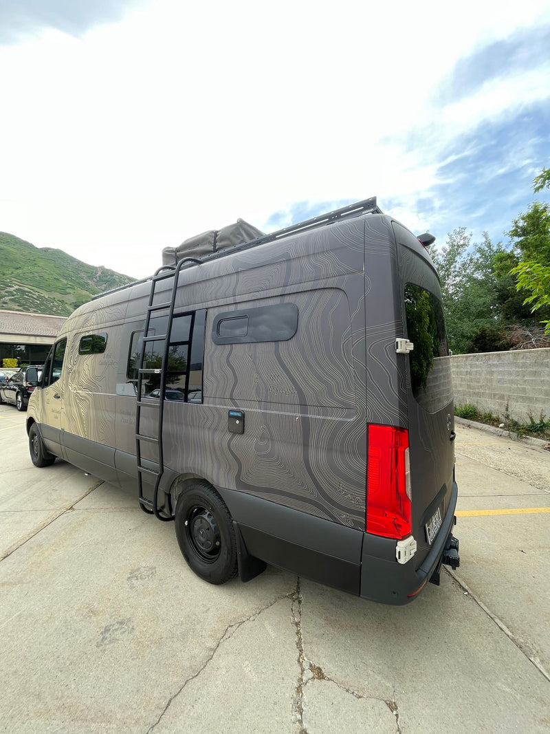  and versatile bench seating.|Cozy camper van RV rental interior. Features a large bed — photo 12