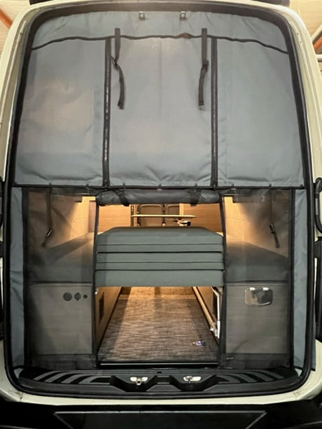 RV rental: Inside a camper van, showing smart storage panels, a neatly folded bed, and functional interior space.