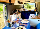 Inviting RV rental camper van interior. Enjoy breakfast, a cozy bed, and nature's beauty from your mobile home.