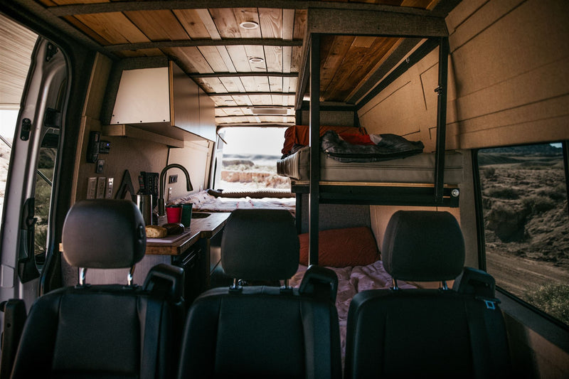  and comfy sleeping areas.|Comfortable RV rental interior: A person sleeps soundly on a lower bunk — photo 9