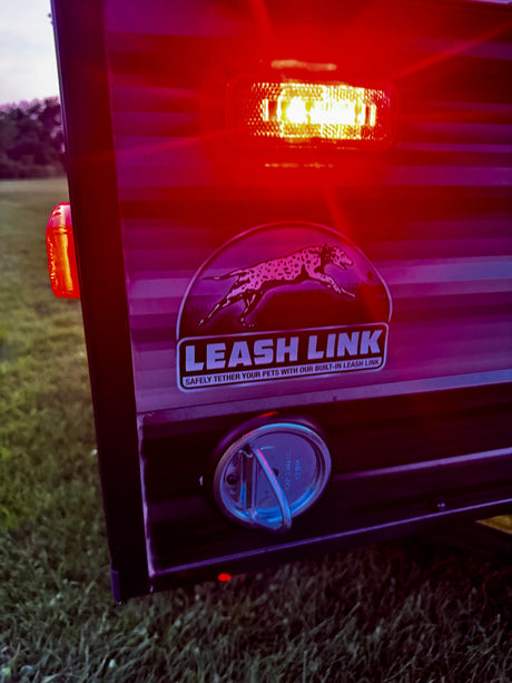 RV rental with a prominent Leash Link pet tether, featuring a dog graphic and a bright light, for safely securing your pets.