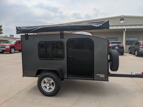 Grey Hiker Highway Deluxe teardrop camper with Rhino-Rack awning, perfect for RV rental adventures.