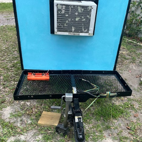 This compact RV rental trailer features a mounted AC unit & front mesh platform for gear. Perfect for travel!