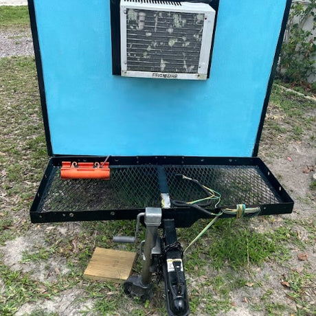 This compact RV rental trailer features a mounted AC unit & front mesh platform for gear. Perfect for travel!