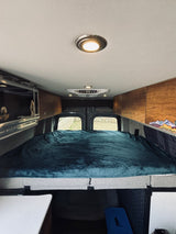 Step inside this RV rental! Features a comfy bed, overhead storage, and microwave, ready for your road trip comfort.