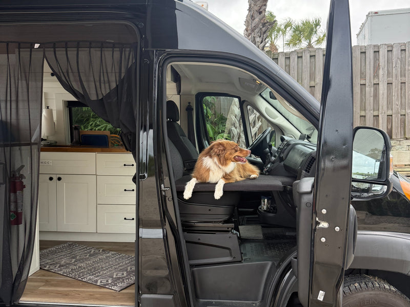  packed for an RV rental journey.|Inside an RV rental van: custom quilted window covers provide privacy/insulation during rainy weather.|A black camper rv rental van — photo 19