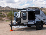 A Freesolo teardrop camper for rv rental, open and ready for adventure in a rugged desert mountain setting.