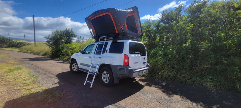 This white SUV with a deployed roof-top tent and ladder is ready for an outdoor 'RV rental' adventure on a dirt road. — photo 5