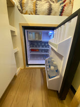 This RV rental features a bright mini-fridge, packed with water bottles and an ice maker, ideal for travel.