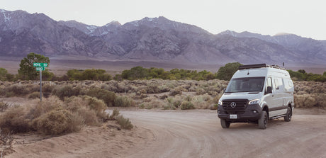 An RV rental (Winnebago Revel) on Movie Rd, backed by rugged mountains. Perfect for your next adventure.