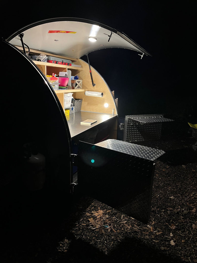  and a large skylight for views.|This cozy RV rental shows a compact wood interior with red & blue sleeping bags — photo 20