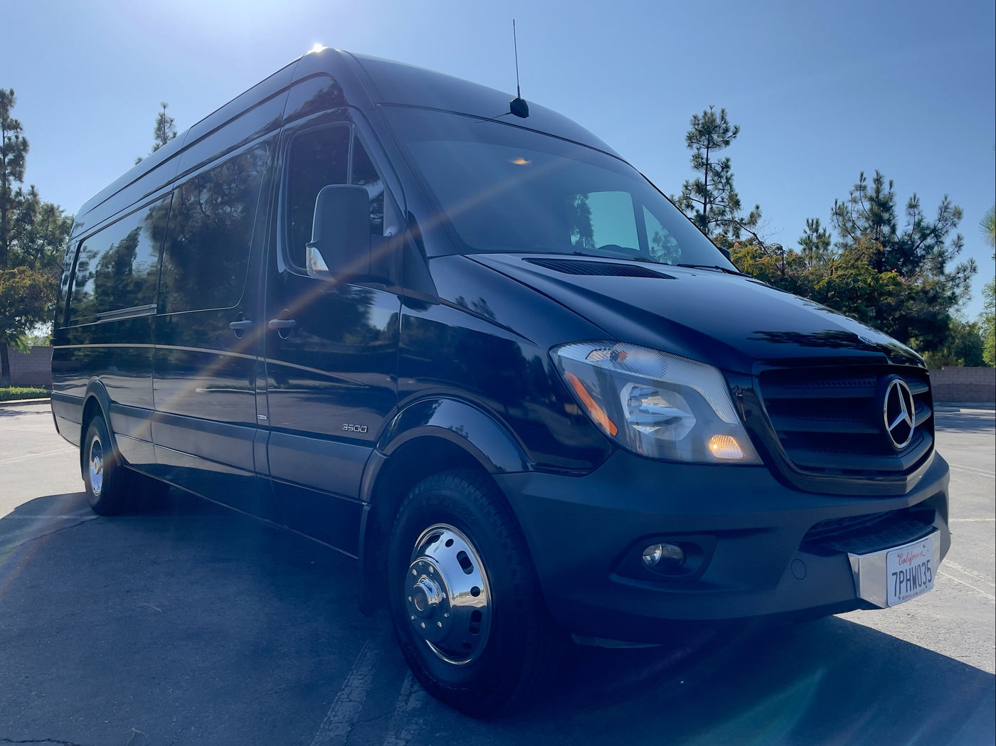 Sleek black Mercedes-Benz Sprinter van, an ideal rv rental, parked in sunlight with prominent chrome wheels. — photo 15