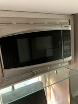 Modern CONTOURE microwave oven, ideal for RV rental adventures. Features an under-mount design with a glass shelf below.