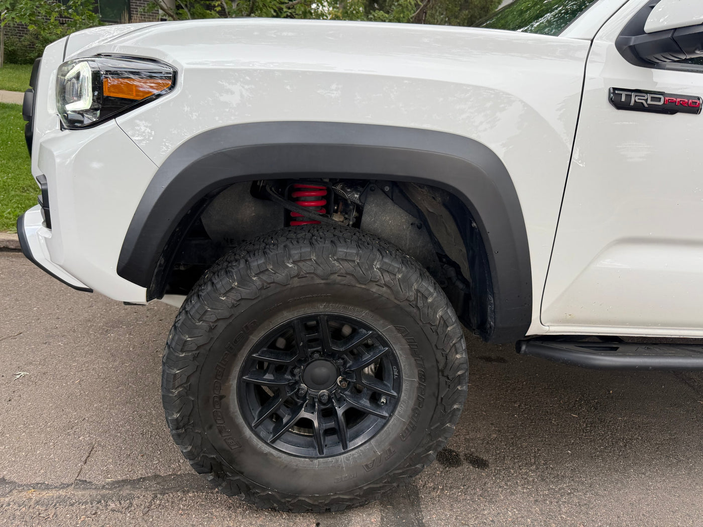 This white Toyota Tacoma TRD Pro truck, with off-road tires and red suspension, is ready for adventure or as a companion to an RV rental trip. — photo 20