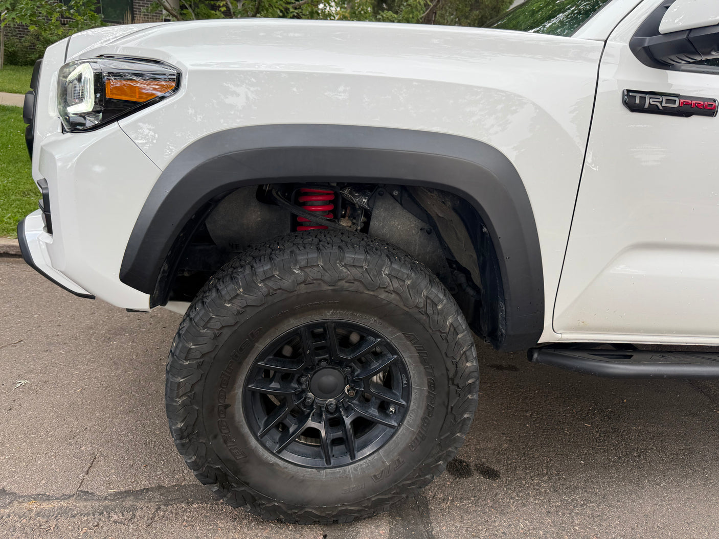 This white Toyota Tacoma TRD Pro truck, with off-road tires and red suspension, is ready for adventure or as a companion to an RV rental trip.